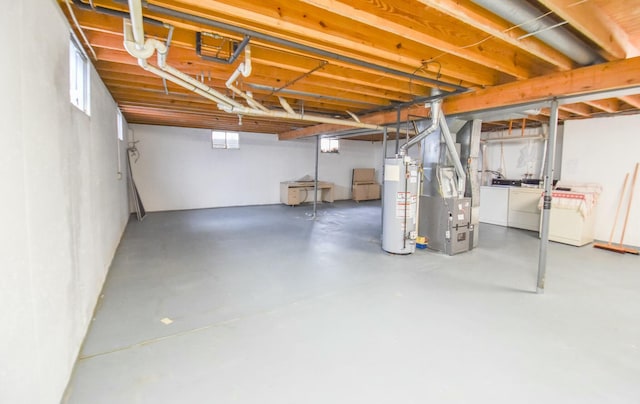 basement with separate washer and dryer, heating unit, and gas water heater