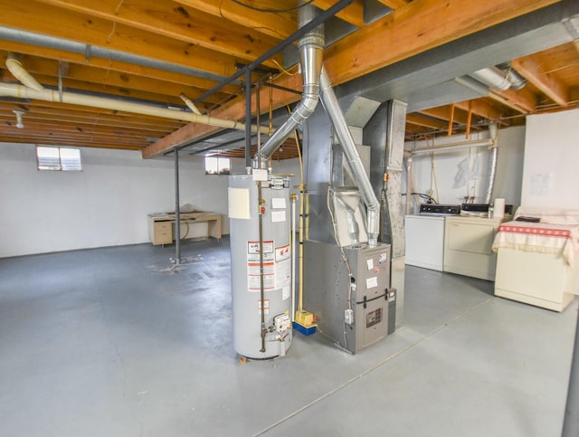 basement featuring heating unit, water heater, and independent washer and dryer