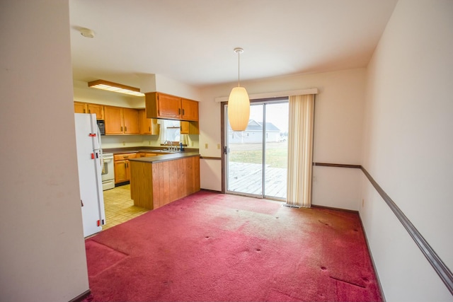 kitchen with white appliances, sink, hanging light fixtures, light colored carpet, and kitchen peninsula