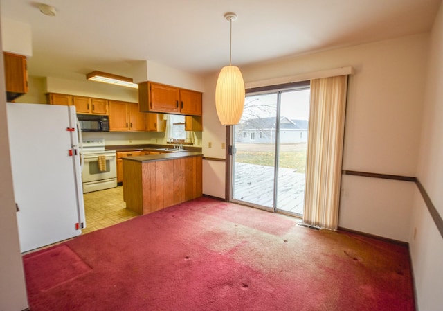 kitchen featuring kitchen peninsula, light colored carpet, sink, electric stove, and decorative light fixtures