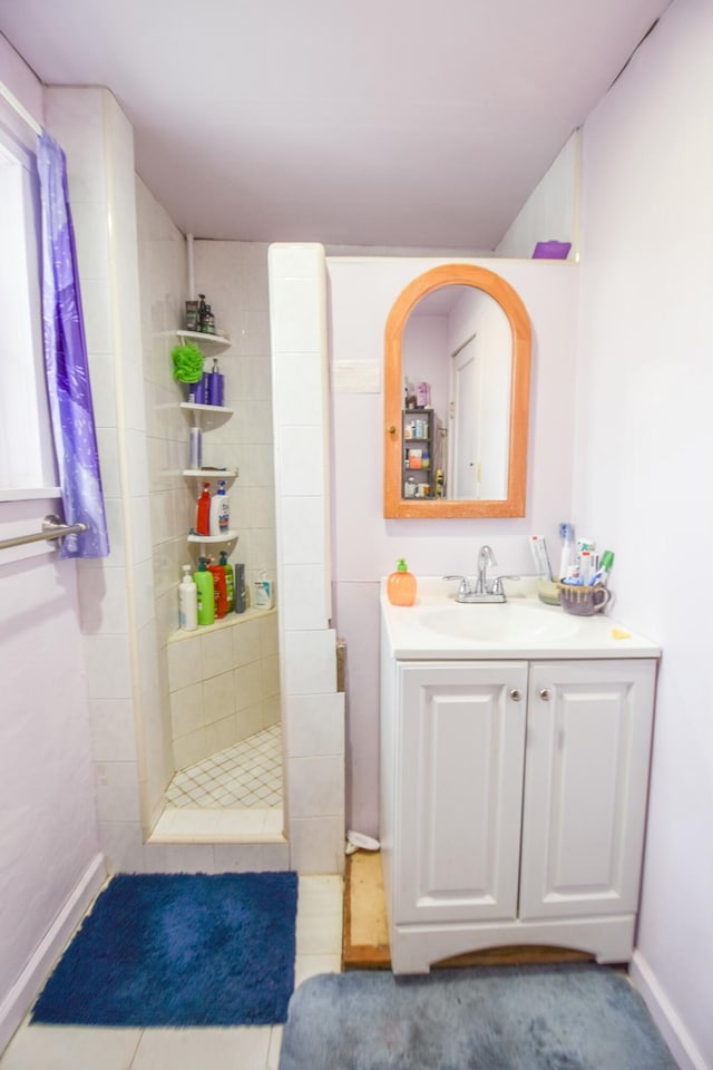 bathroom featuring tile patterned floors, vanity, and a tile shower