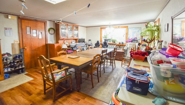 dining space with wood-type flooring and ornamental molding