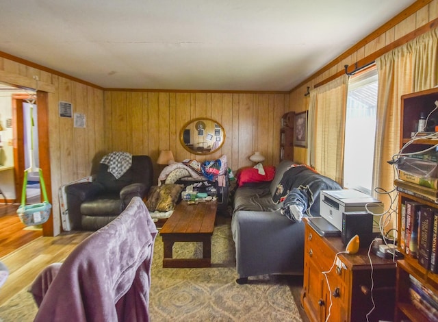 living room featuring wood walls, hardwood / wood-style floors, and crown molding