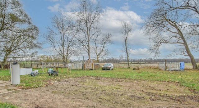 view of yard featuring a rural view and a shed