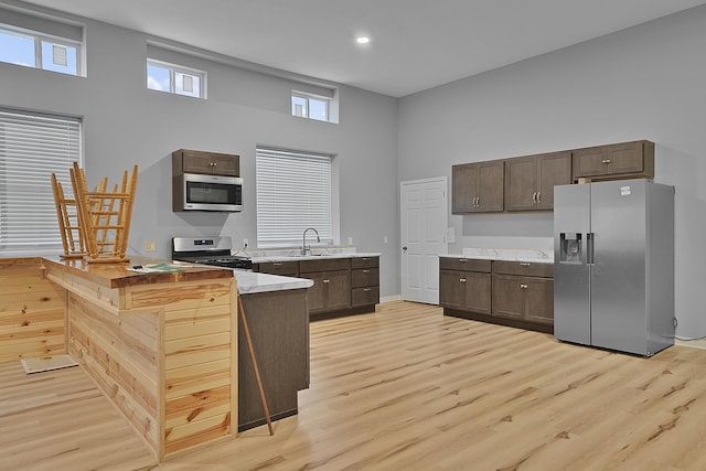 7564 13 Mile Rd NE, Rockford, MI 49341 - kitchen featuring sink, appliances with stainless steel finishes, light wood-type flooring, and a high ceiling