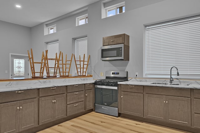 7564 13 Mile Rd NE, Rockford, MI 49341 - kitchen featuring stainless steel appliances, light hardwood / wood-style flooring, a wealth of natural light, and sink