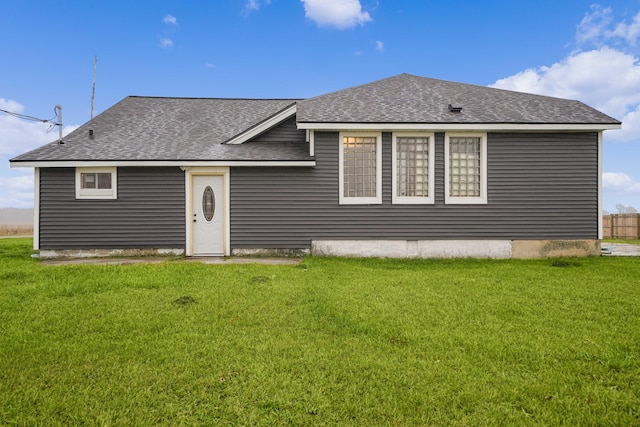 rear view of house featuring a lawn