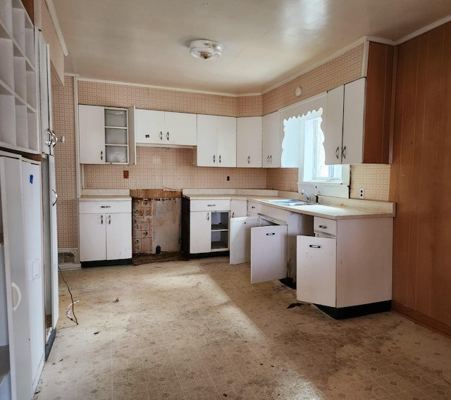 kitchen with backsplash, crown molding, sink, and white cabinets