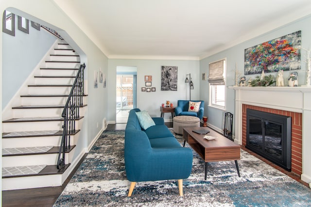 living room with dark hardwood / wood-style flooring, a brick fireplace, and a wealth of natural light