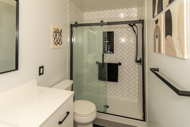 bathroom featuring vanity, toilet, and an enclosed shower