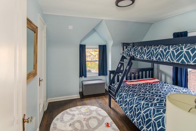 bedroom with dark hardwood / wood-style floors and lofted ceiling