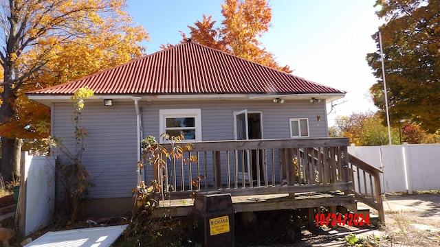 rear view of house featuring a wooden deck