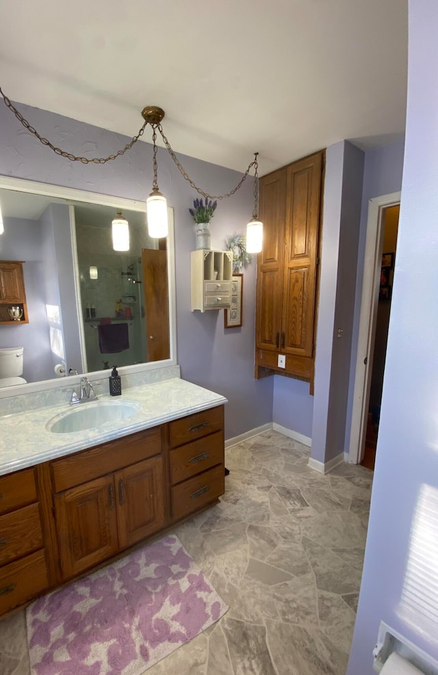 bathroom with vanity, toilet, and a shower