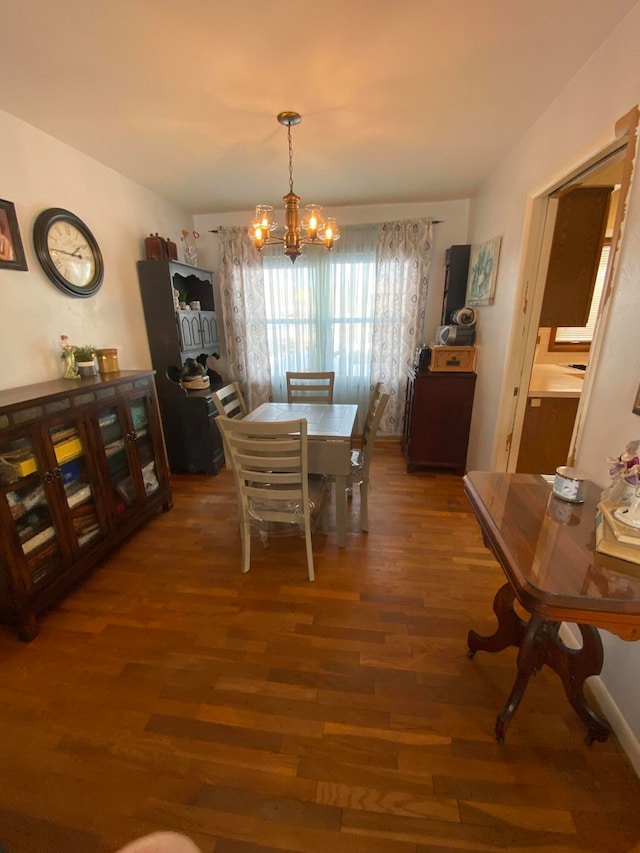 dining space featuring dark hardwood / wood-style flooring and a chandelier