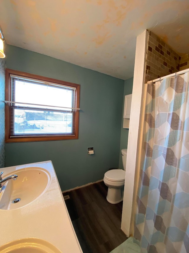 bathroom featuring vanity, toilet, wood-type flooring, and walk in shower