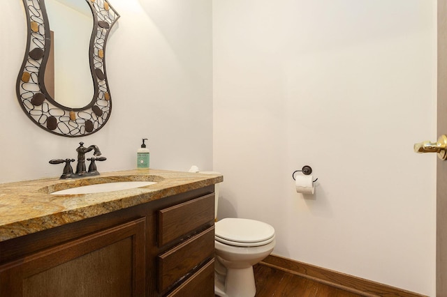 bathroom with hardwood / wood-style floors, vanity, and toilet