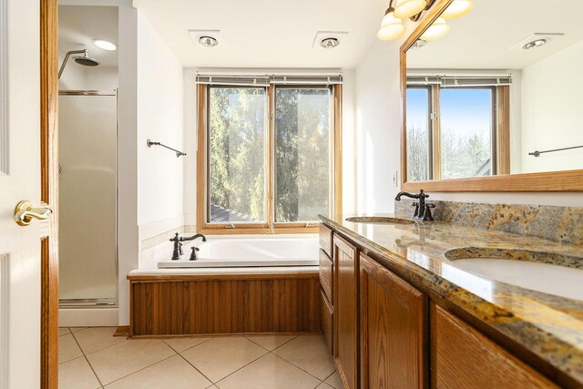 bathroom featuring tile patterned floors, independent shower and bath, vanity, and a healthy amount of sunlight