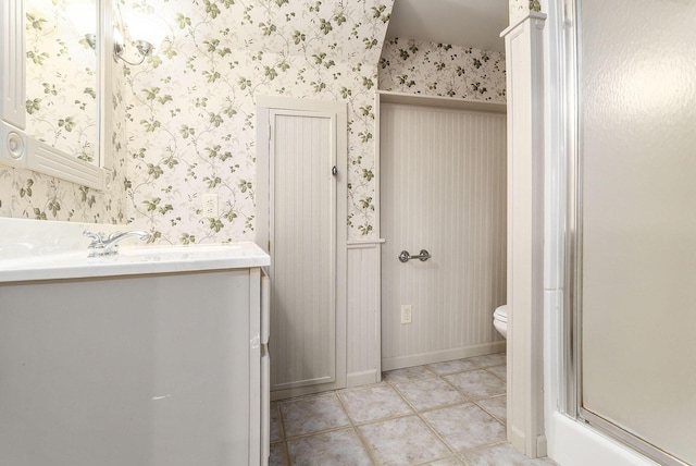 bathroom featuring tile patterned flooring, vanity, toilet, and an enclosed shower