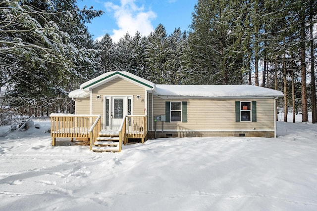 snow covered house featuring a wooden deck