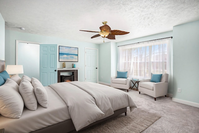 carpeted bedroom featuring ceiling fan and a textured ceiling