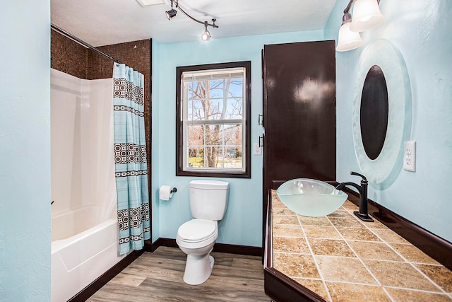 full bathroom with shower / bath combo, hardwood / wood-style floors, a textured ceiling, toilet, and vanity