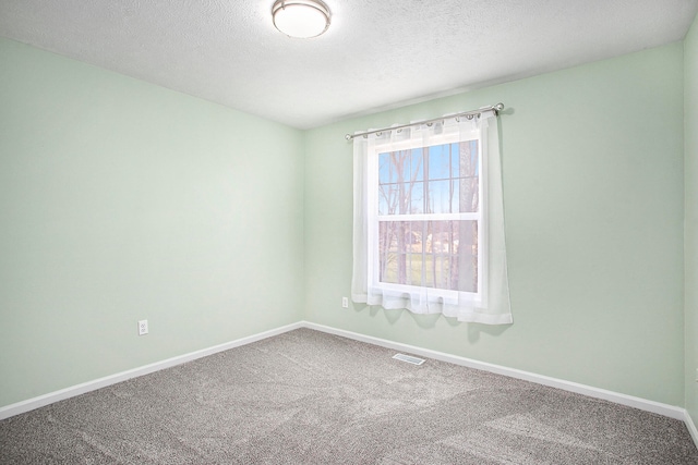 carpeted spare room featuring a textured ceiling