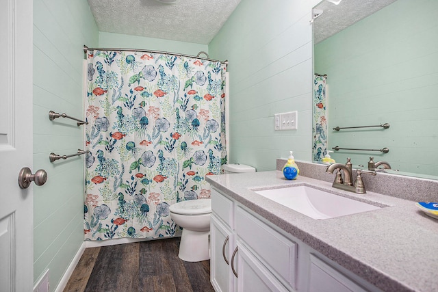 bathroom with hardwood / wood-style floors, vanity, a textured ceiling, and toilet