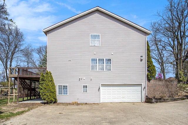 back of property with a wooden deck and a garage