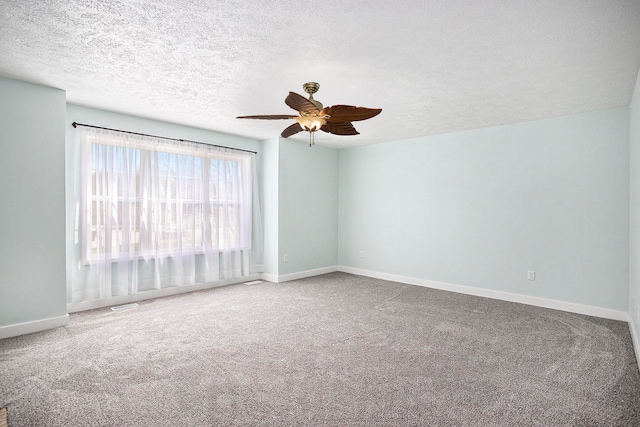 empty room featuring carpet flooring, ceiling fan, and a textured ceiling