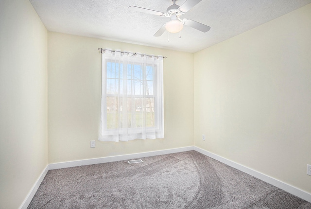 empty room with ceiling fan, carpet floors, and a textured ceiling