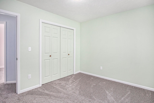 unfurnished bedroom featuring a closet, carpet, and a textured ceiling