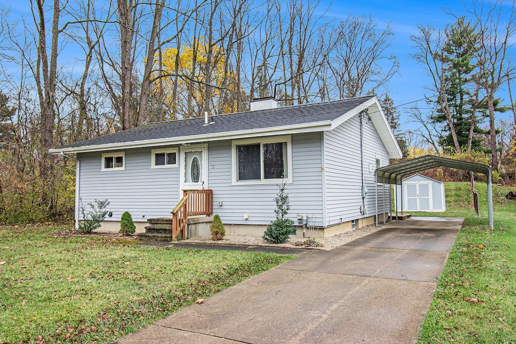 view of front of property featuring a storage unit and a front yard