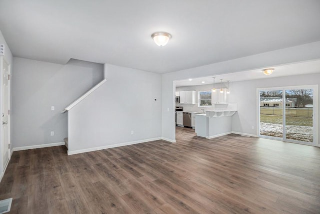 unfurnished living room with dark hardwood / wood-style flooring