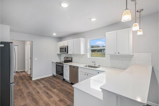 kitchen with kitchen peninsula, white cabinets, and appliances with stainless steel finishes