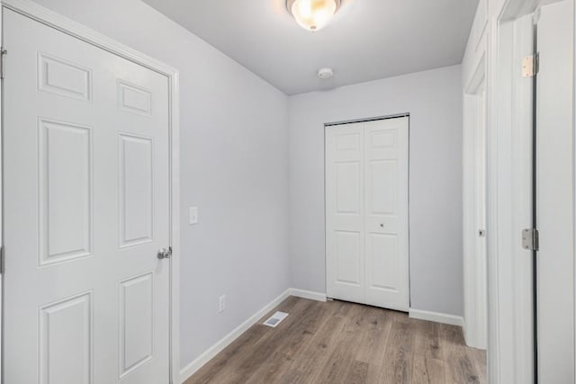 unfurnished bedroom with a closet and light hardwood / wood-style flooring