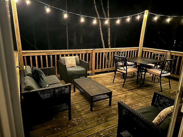 deck at night featuring an outdoor living space