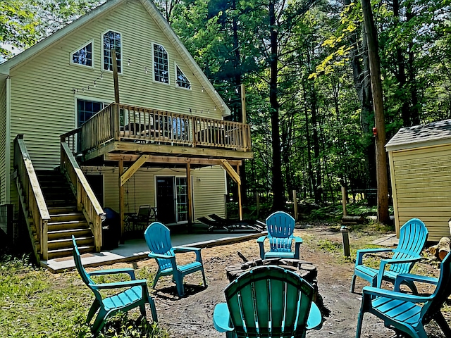 rear view of house with a patio, an outdoor fire pit, and a wooden deck