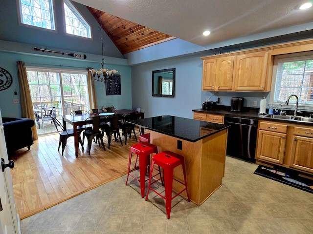 kitchen featuring a breakfast bar, sink, light hardwood / wood-style flooring, dishwasher, and a center island