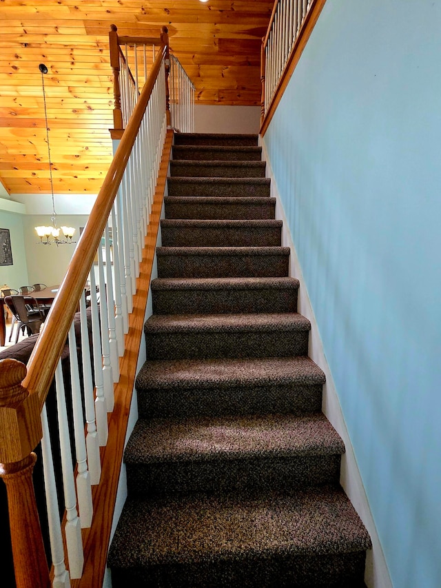 stairway with wood-type flooring, wooden ceiling, and an inviting chandelier