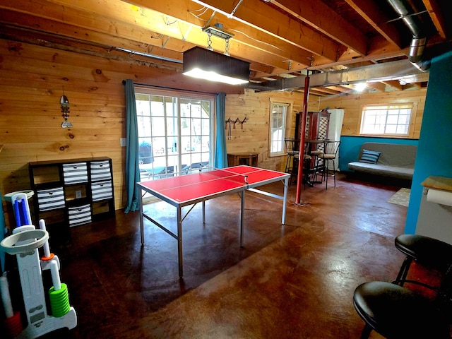 recreation room with a healthy amount of sunlight and wooden walls