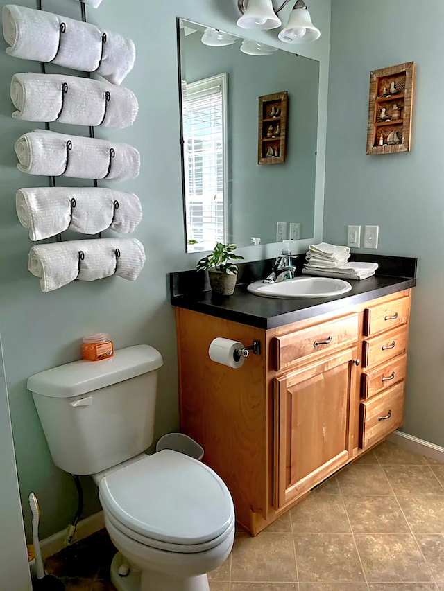 bathroom with tile patterned flooring, vanity, and toilet