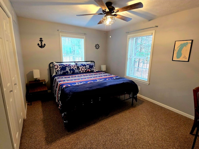 carpeted bedroom with multiple windows, a closet, and ceiling fan