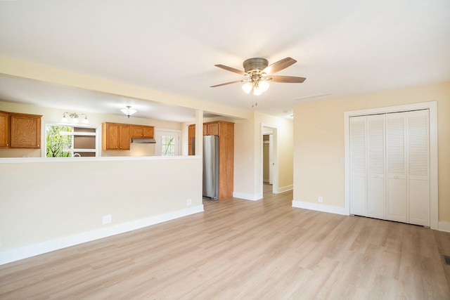 unfurnished living room with ceiling fan and light hardwood / wood-style flooring