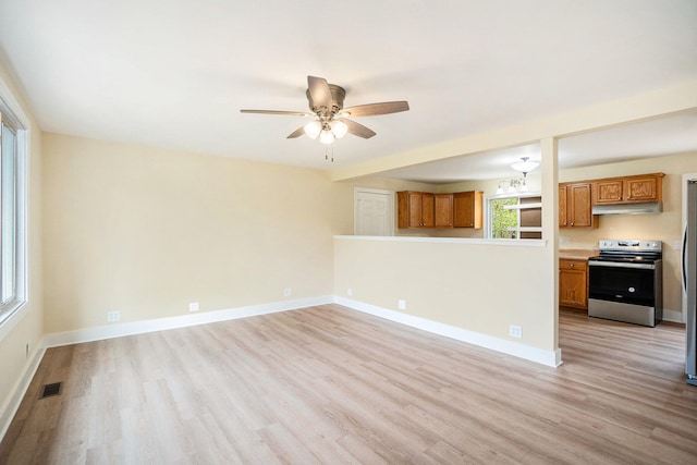 unfurnished living room featuring ceiling fan and light wood-type flooring