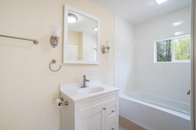 bathroom with vanity, wood-type flooring, and tiled shower / bath