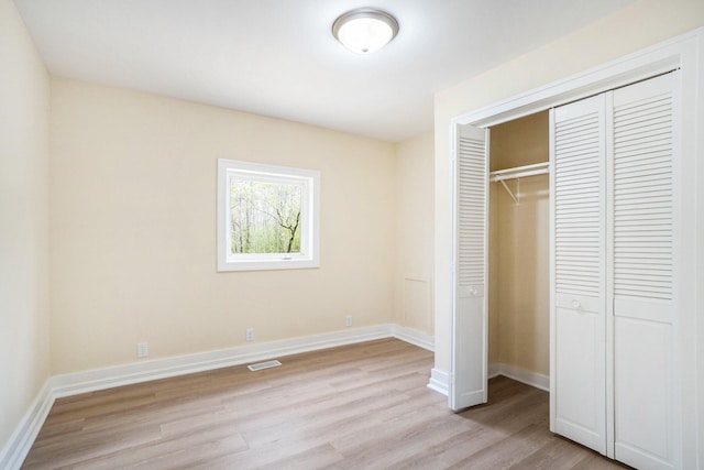 unfurnished bedroom featuring a closet and light wood-type flooring