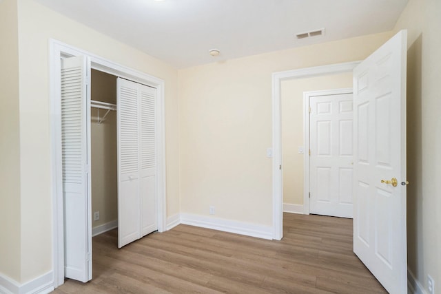 unfurnished bedroom featuring light hardwood / wood-style floors and a closet