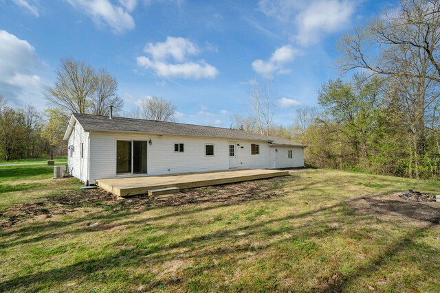 rear view of house featuring a lawn, a wooden deck, and central AC