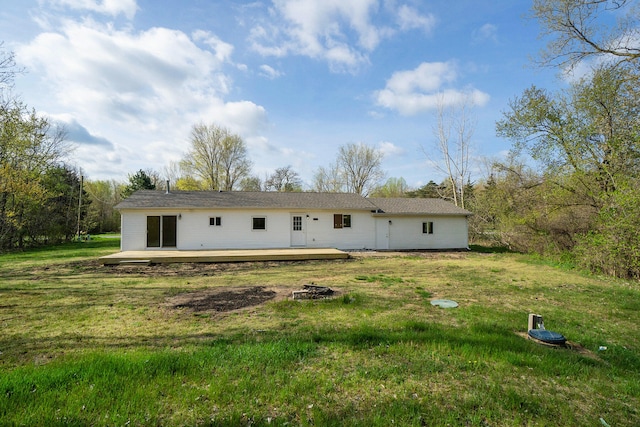 rear view of house with a lawn and a wooden deck