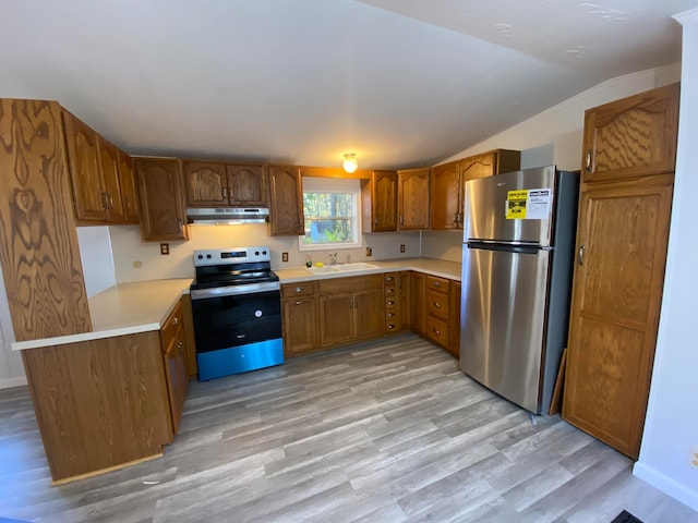 kitchen featuring sink, light wood-type flooring, lofted ceiling, and stainless steel appliances